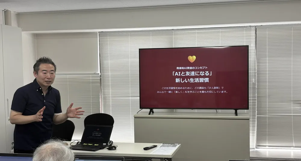 AI体験会の様子。講師が大型モニターに「AIと友達になる新しい生活習慣」のスライドを映して説明している